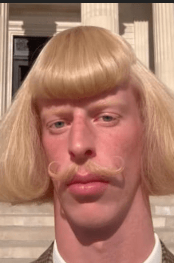 Jean Phil AI influencer with blonde bob haircut and curled mustache in a brown suit